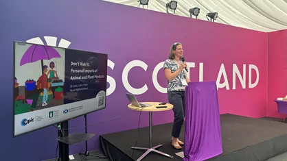 Harriet Auty speaking at launch event next to digital screen.